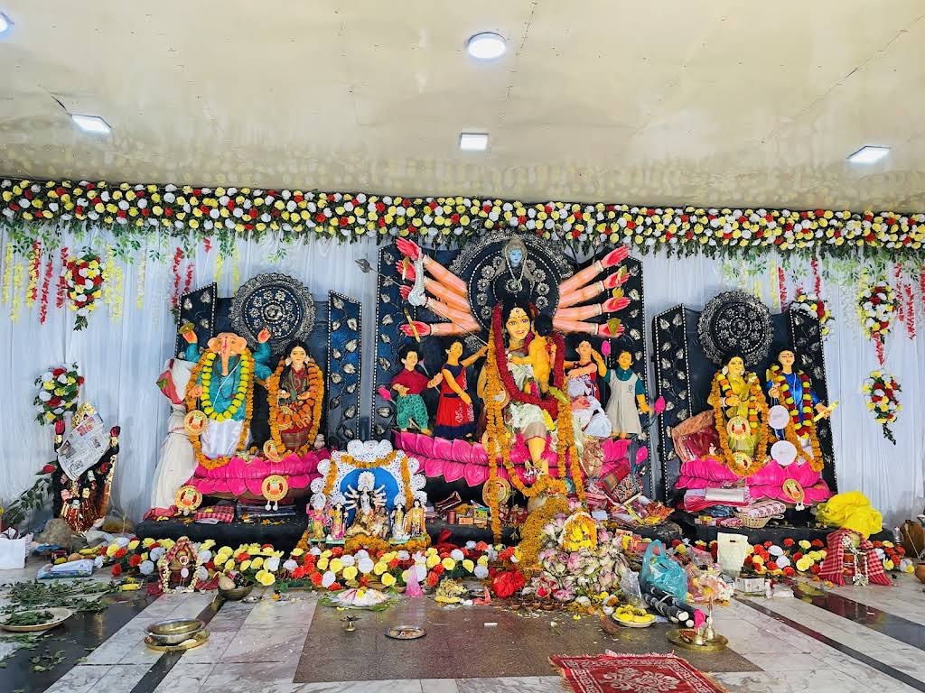 Durga tableau with floral garlands and offerings, Kolaj Durga Puja